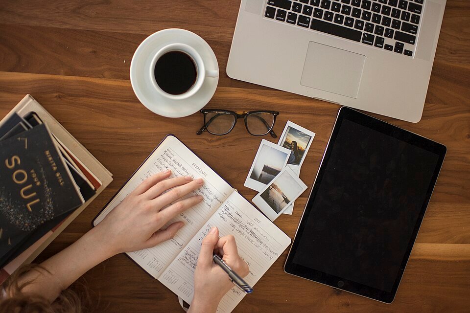 A journal beside a cup of coffee