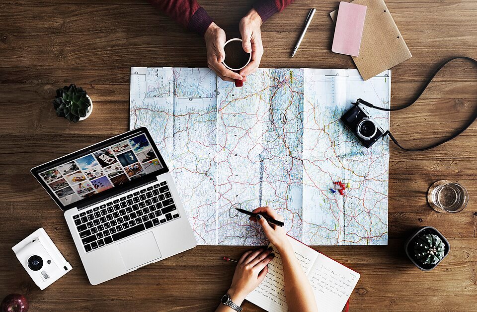 Travel planning materials beside a coffee